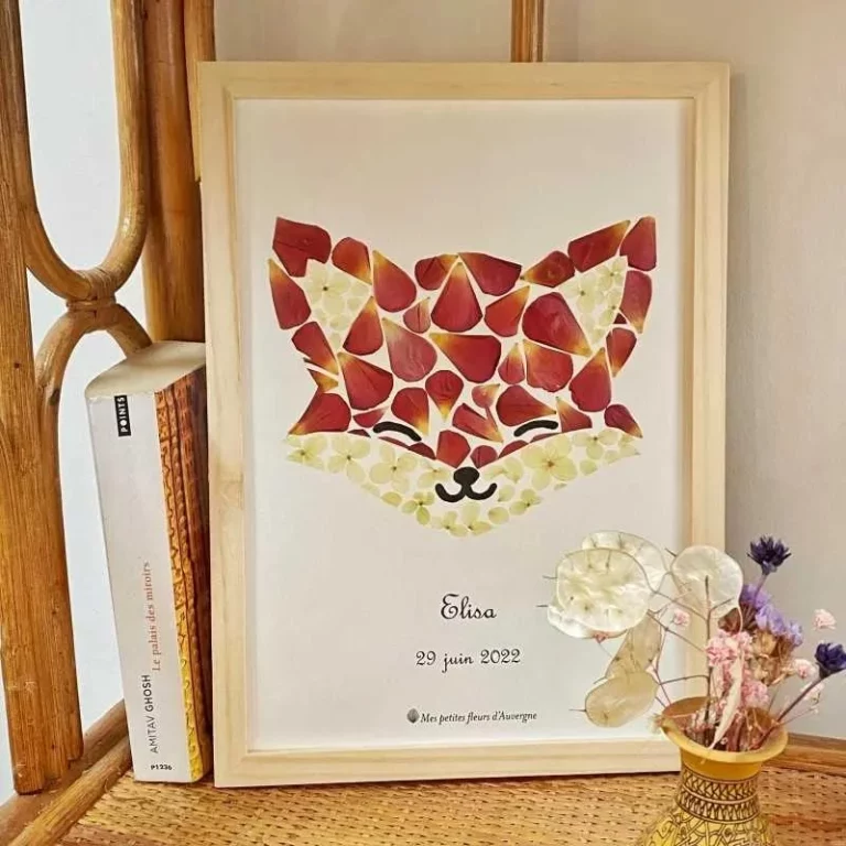 Cadre en bois contenant un herbier créatif en forme de tête de renard fait avec des pétales de fleurs rouges et blanches.