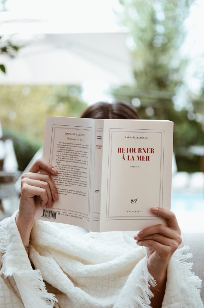 A woman sitting on a couch reading a book
